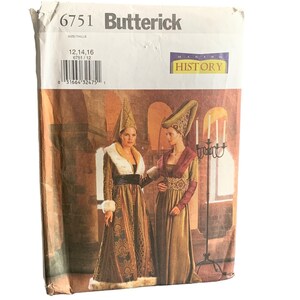 May include: A Butterick sewing pattern envelope featuring two women in medieval-style gowns. The envelope is labeled "6751 Butterick" with size information and a "Making History" logo. The gowns are brown and gold with fur trim and matching headwear.