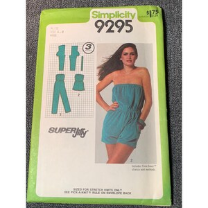 May include: A vintage Simplicity 9295 sewing pattern featuring a teal romper and pants design. The pattern includes illustrations of the garments and the text "SUPER Jiffy". The package is green and white with the price $1.75.