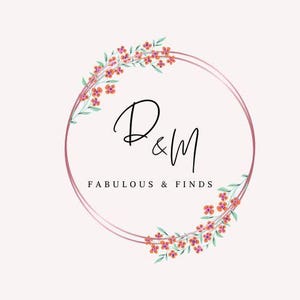 K&ouml;nnte beinhalten: Ein Logo mit einem doppelten rosa Kreis, den Buchstaben "D&M" in eleganter schwarzer Schrift und den Worten "FABULOUS & FINDS" darunter. Florale Akzente mit orangefarbenen Bl&uuml;ten und gr&uuml;nen Bl&auml;ttern schm&uuml;cken den Kreis.