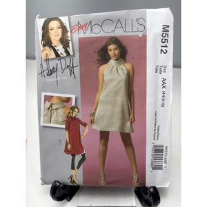 May include: A McCall's sewing pattern featuring a halter dress design. The pattern packet includes a photo of Hilary Duff and the text "hilaryduff.com". The pattern size is AAX (4-6-8-10).