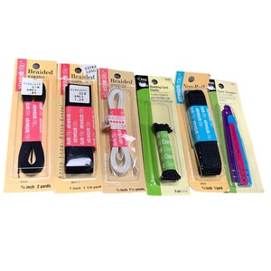 May include: Assortment of sewing supplies, including black and white braided elastic, white cord, and elastic threaders. The packages display product names and measurements in inches and yards. Ideal for crafting and sewing projects.
