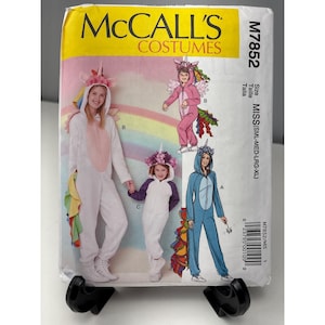 May include: McCall's Costumes pattern M7852 featuring unicorn costumes in white, pink, and blue. The pattern includes sizes for Misses (SML-MED-LRG-XL). The packaging is yellow and white with images of the finished costumes.