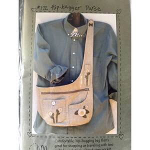 May include: A light-colored hip-hugger purse with a long strap, two front pockets, and a zipper closure. The purse is decorated with floral and cactus-like appliqués. The text "#172 Hip-hugger Purse" is visible at the top.