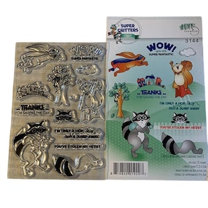 May include: Clear stamp set featuring cartoon animals, including a rabbit, squirrel, and raccoon. The set includes stamps with phrases like "WOW!" and "Thanks for saving the day." The packaging indicates the set includes 13 stamps, with the largest stamp measuring 2.3 x 1.5 inches.
