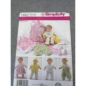 May include: Simplicity pattern 1952 for 15-inch doll clothes. The pattern includes a backpack, dress, bib, hat, pants, and shoes. The doll clothes are pink, yellow, and white. The pattern is one size.