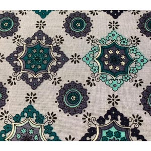 Puede incluir: Primer plano de una tela con un patrón repetitivo de diseños florales y geométricos turquesa, gris y azul oscuro. El patrón incluye flores estilizadas y formas de diamante sobre un fondo gris claro. La tela tiene una estética vintage o retro.