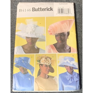 May include: A Butterick B4146 sewing pattern envelope featuring illustrations of five different hat styles. The hats include a white wide-brimmed hat with bows, a peach-colored structured hat, a blue hat with a side bow, a tan hat with floral accents, and a light blue hat with a bow.