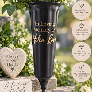 May include: A black plastic memorial flower vase with a pointed spike base for ground insertion. The vase features vertical fluting and gold text that reads In Loving Memory Of Helen Love. It is designed to hold fresh or artificial flowers.