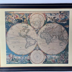 May include: A rectangular placemat featuring a detailed antique world map design. The map is in shades of beige, blue, and brown, with decorative figures and text. The placemat has a black border.