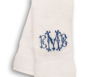 May include: White hand towel with a blue embroidered monogram "KMB" in a decorative script font.