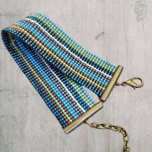 May include: A blue, green, and brown beaded bracelet with a brass clasp and chain.