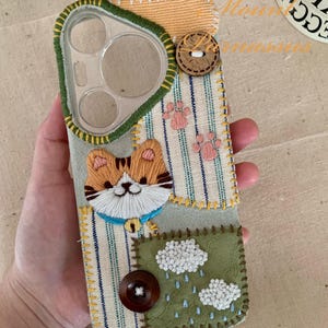 Individuell gestickte Katzen-Handyhülle | Gelbe Kitty mit Wolken & Pfotenabdrücken | Handgefertigte Stoffhülle mit Knopf Details