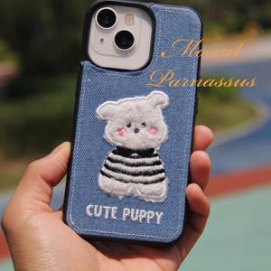 Custodia per iPhone in denim azzurro chiaro con motivo a cartoni animati – Cucciolo bianco ricamato in un maglione accogliente, accessorio chic per gli amanti degli animali e dello stile urbano
