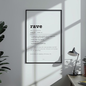 Puede incluir: Una impresión en blanco y negro enmarcada con la definición de la palabra "rave". La definición incluye frases como "sweaty side-quest heaven" y "the bestest form of self-care". La impresión se muestra en una pared blanca.