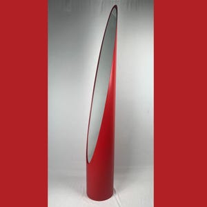 May include: A tall, red, modern floor mirror with a sleek, curved design. The mirror has a silver reflective surface and a bold, minimalist aesthetic, suitable for home decor.