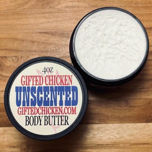 Puede incluir: Un tarro de 113 g de manteca corporal sin perfume con tapa negra y una etiqueta blanca que dice "Gifted Chicken Unscented Giftedchicken.com Body Butter".