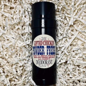 May include: A black deodorant stick with a white label. The label reads "GIFTED CHICKEN POWDER FRESH" in red and blue, with ingredients and the size, 57g. The product is set against a white paper background.