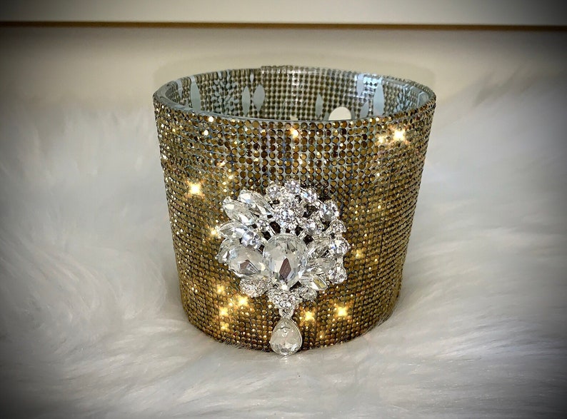 Gold crystal rhinestone container candle with clear crystal drop embellishment.