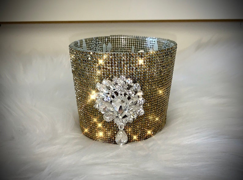 Gold crystal rhinestone container candle with clear crystal drop embellishment.