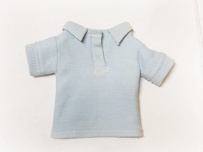 May include: A light blue collared shirt with short sleeves.
