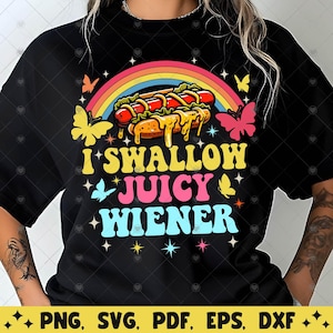 Op de afbeelding: Een zwart T-shirt met een regenbooggrafiek en de tekst "I Swallow Juicy Wiener". De grafiek toont een hotdog met mosterd en ketchup.