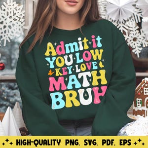 Könnte beinhalten: Ein dunkelgrüner Pullover mit dem Text "Admit it You Low Key Love Math Bruh" in bunten Buchstaben. Der Text ist in einem Retro-Schriftart-Stil.