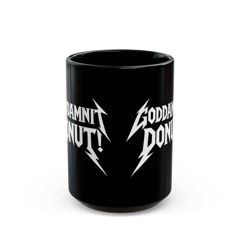 Black ceramic mug with bold white text in a Metallica-style font that reads “Goddamnit Donut,” inspired by Dungeon Crawler Carl. The mug is set on a modern kitchen counter, perfect for fans of LitRPG, Princess Donut, and Matt Dinniman's cult book series. Ideal for coffee or tea lovers who enjoy a mix of humor, chaos, and fandom in their daily routine.
