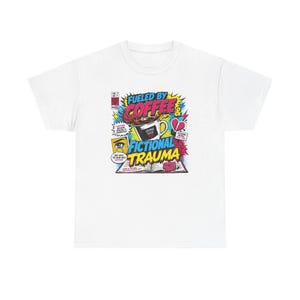 Pu&ograve; includere: T-shirt bianco con grafica in stile fumetto. La grafica include il testo "Fueled by Coffee & Fictional Trauma" con immagini di una tazza di caff&egrave;, un cuore spezzato e un libro aperto.