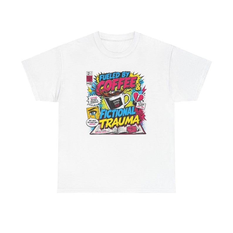 Pu&ograve; includere: T-shirt bianco con grafica in stile fumetto. La grafica include il testo "Fueled by Coffee & Fictional Trauma" con immagini di una tazza di caff&egrave;, un cuore spezzato e un libro aperto.