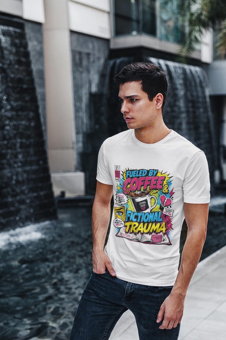 Young man wearing white Fueled by Coffee and Fictional Trauma bookish graphic tee in urban outdoor setting, funny reader shirt book lover gift