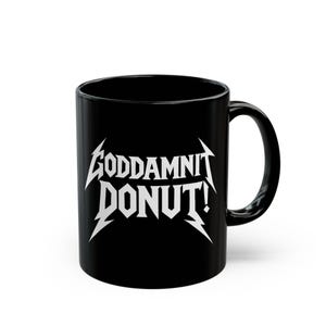 Black ceramic mug with bold white text in a Metallica-style font that reads “Goddamnit Donut,” inspired by Dungeon Crawler Carl. The mug is set on a modern kitchen counter, perfect for fans of LitRPG, Princess Donut, and Matt Dinniman's cult book series. Ideal for coffee or tea lovers who enjoy a mix of humor, chaos, and fandom in their daily routine.