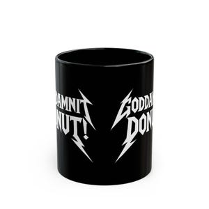 Black ceramic mug with bold white text in a Metallica-style font that reads “Goddamnit Donut,” inspired by Dungeon Crawler Carl. The mug is set on a modern kitchen counter, perfect for fans of LitRPG, Princess Donut, and Matt Dinniman's cult book series. Ideal for coffee or tea lovers who enjoy a mix of humor, chaos, and fandom in their daily routine.