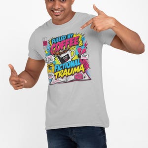Man in light grey tee pointing at Fueled by Coffee and Fictional Trauma graphic, white background, bookish gift for readers