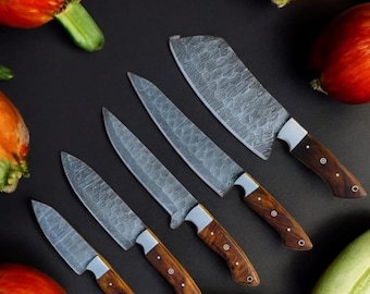 May include: A set of six kitchen knives with wooden handles and a Damascus steel blade. The knives are arranged on a black surface with red and orange fruits.
