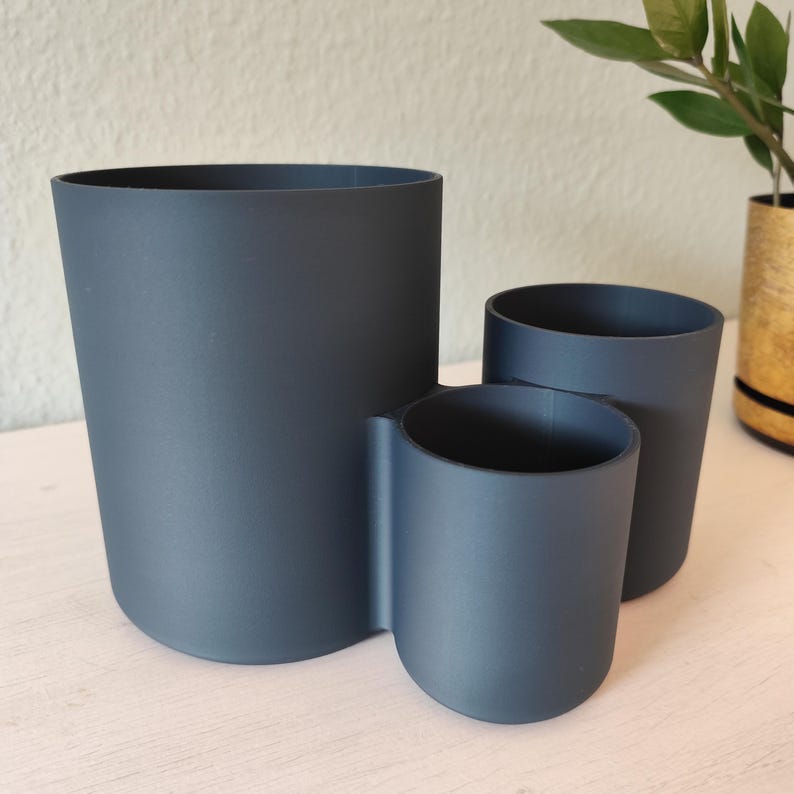 May include: A white ceramic mug with a black handle and the text "But First, Coffee" in a black, bold font. The mug is on a white surface.