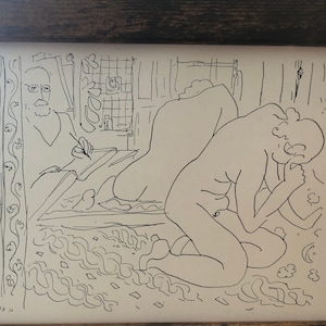 Puede incluir: Dibujo en blanco y negro de dos figuras en una habitación. La figura de la izquierda está sentada y parece estar escribiendo. La figura de la derecha está arrodillada y mirando hacia abajo. El dibujo está enmarcado en un marco de madera.