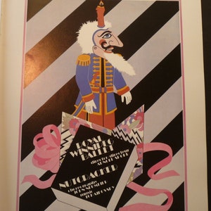 May include: A vintage poster for the Royal Winnipeg Ballet's production of The Nutcracker, featuring a colorful illustration of a Nutcracker doll in a blue and gold uniform, with a pink ribbon and a box with the title "The Nutcracker" in black text.