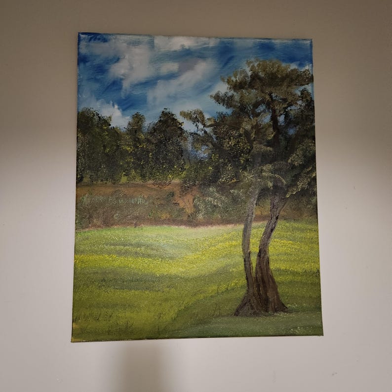 K&ouml;nnte beinhalten: Ein Gem&auml;lde, das eine Landschaft mit einem gro&szlig;en Baum im Vordergrund zeigt. Der Baum hat einen dicken Stamm und &Auml;ste, die sich zum Himmel erstrecken. Der Hintergrund ist ein Feld mit gr&uuml;nem Gras und einem blauen Himmel mit wei&szlig;en Wolken.