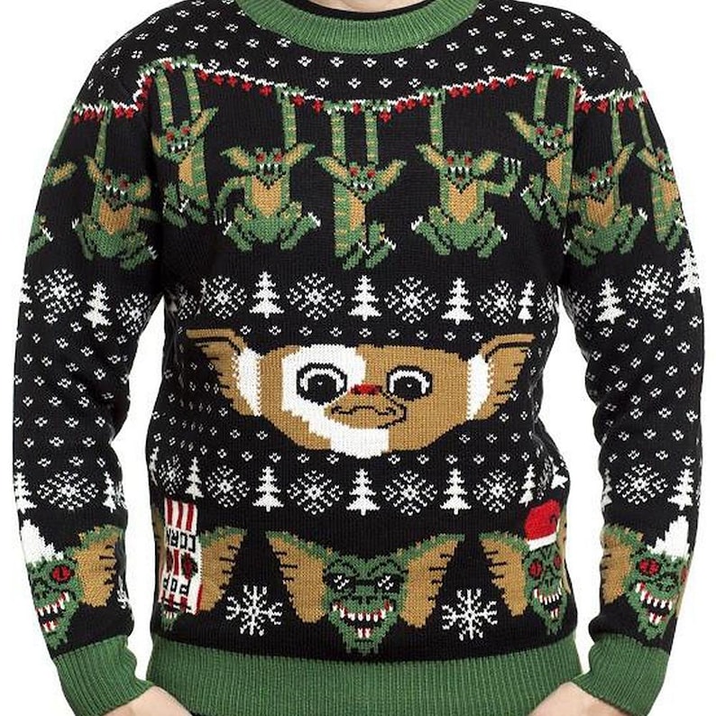 May include: Black Christmas sweater with a green, white, and red pattern. The sweater features a graphic of the character 'Gizmo' from the movie 'Gremlins'.