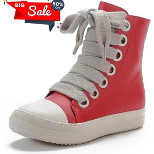 May include: Red high-top sneaker with a white toe cap and sole. The shoe features gray laces and metal eyelets. A red banner with the text "Big Sale" and "50% Off" is in the upper left corner.