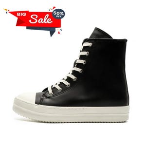 May include: Black high-top sneaker with white laces and a white sole. The toe cap is white, and the shoe has a tall, sleek design. A red and white "Big Sale" banner with a 50% off tag is in the upper left corner.