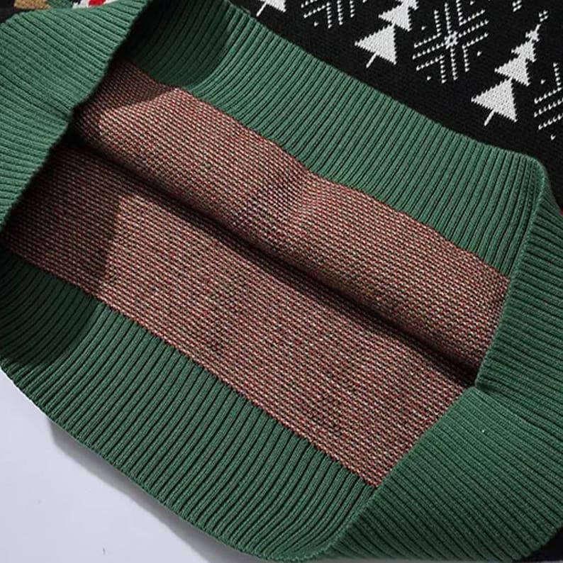 May include: Close-up of the inside of a black and green sweater with a red and white snowflake pattern. The sweater is made of a soft, knitted fabric.