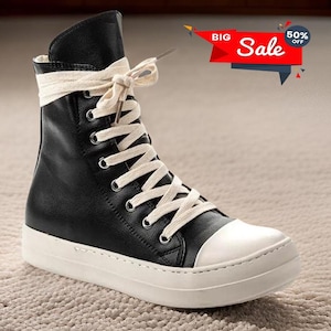 May include: Black leather high-top sneakers with white laces and a white rubber sole. The laces are tied in a bow at the top of the shoe.