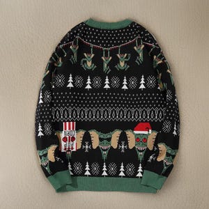 May include: Black Christmas sweater with a green, white, and red pattern. The sweater features a graphic of a creature from the movie 'Gremlins' with the text 'Corn' and 'Pop' on a red and white striped box.