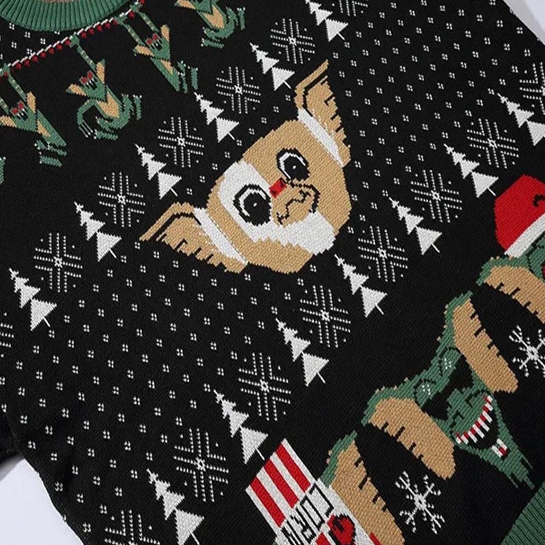 May include: Black Christmas sweater with a white and brown dog, a green creature, and a red and white striped candy cane. The sweater has a snowflake pattern.