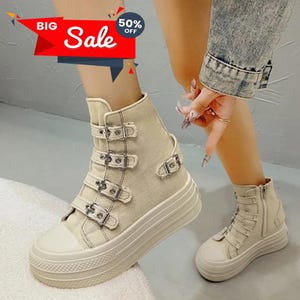 May include: Beige high-top platform sneakers with multiple buckle closures. The sneakers have a white toe cap and a thick, ridged sole. The image also includes a "BIG Sale" banner with a 50% off promotion.