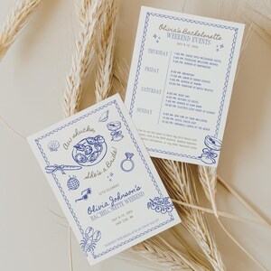 May include: Two white cards with blue text and illustrations. One card reads "Olivia Johnson's Bachelorette Weekend" with a list of events. The other card says "Aw shucks, She's a Bride!" with illustrations of a ring, food, and other items.