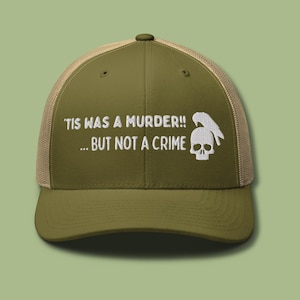 Puede incluir: Una gorra de camionero verde y beige con el texto "'Tis was a murder!! ... but not a crime" y un gráfico de calavera y pájaro bordado en la parte delantera.