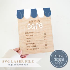 May include: Wooden cafe sign with a blue and white awning design. The sign reads "Kaiden's Cafe" in white script, listing menu items like babyccino, milkshake, and ice cream. A digital download is available.