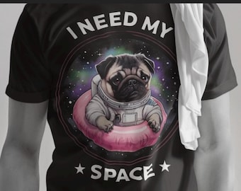 May include: Black t-shirt with a white circle graphic featuring a pug wearing an astronaut suit and floating in space. The text "I NEED MY SPACE" is printed above the graphic.